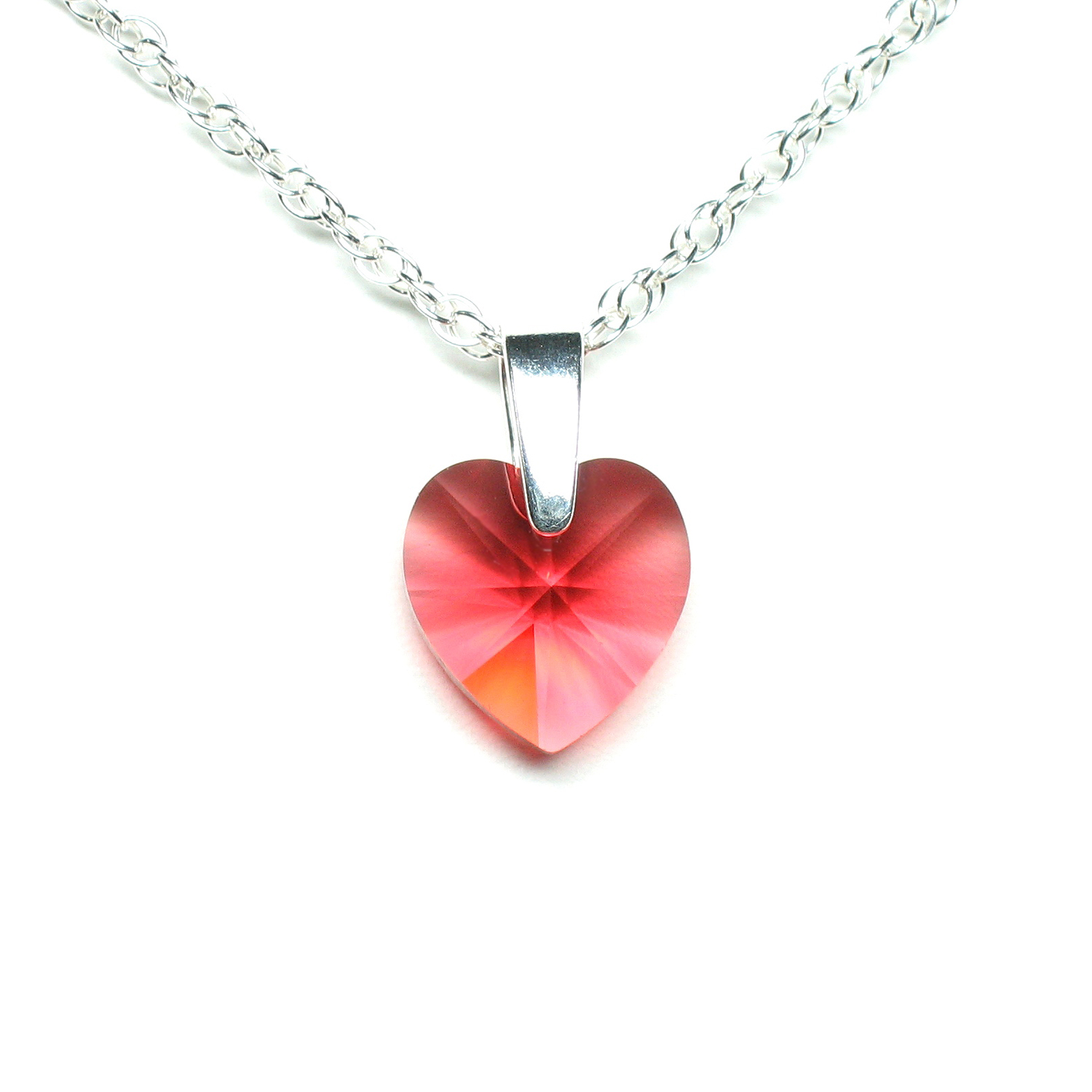 Coral crystal heart pendant on a sterling silver chain.